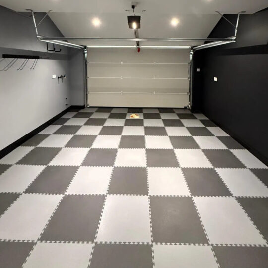 Empty garage showcasing black and white chequered Duramat interlocking floor tile installation