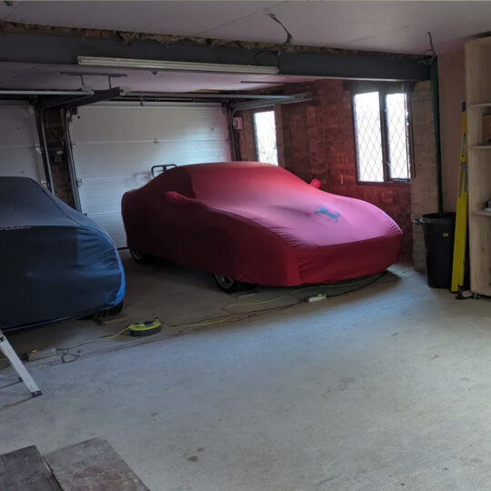 Cars stored under protective covers in a residential garage