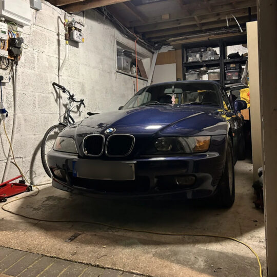 Dark blue BMW Z3 coupe parked in a residential garage workshop