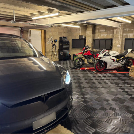 Car cave interior with Tesla and motorcycles on chequered Duramat garage flooring